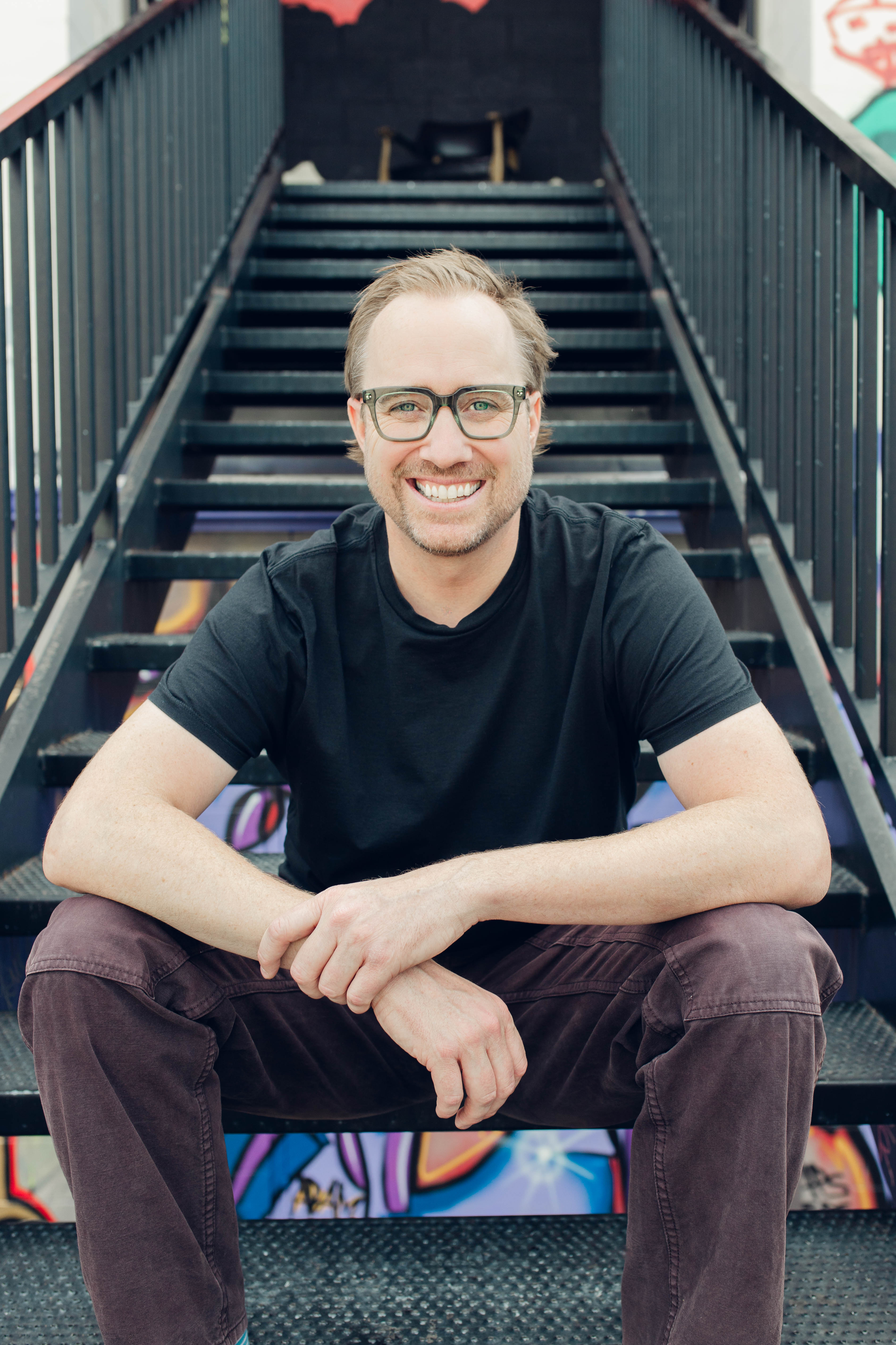 Family sitting around a fire pit in front of cabin